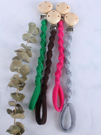 Attache Tétine Macramé Amory Atelier Macramé toutes les couleurs sur une table grise