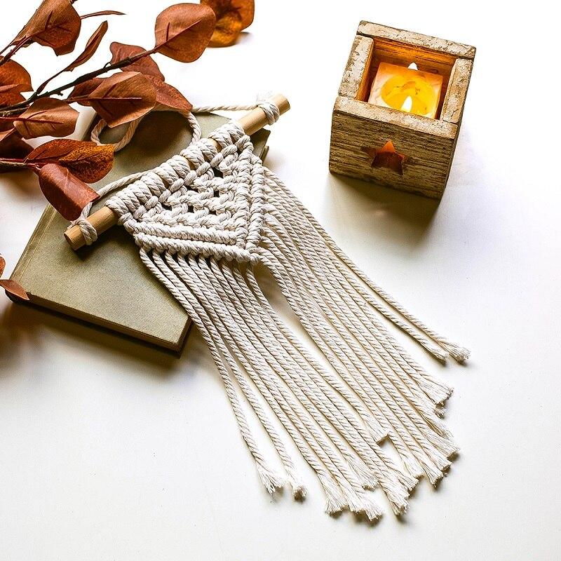 Macramé Mural Loëza Atelier Macramé avec une bougie et des feuilles mortes