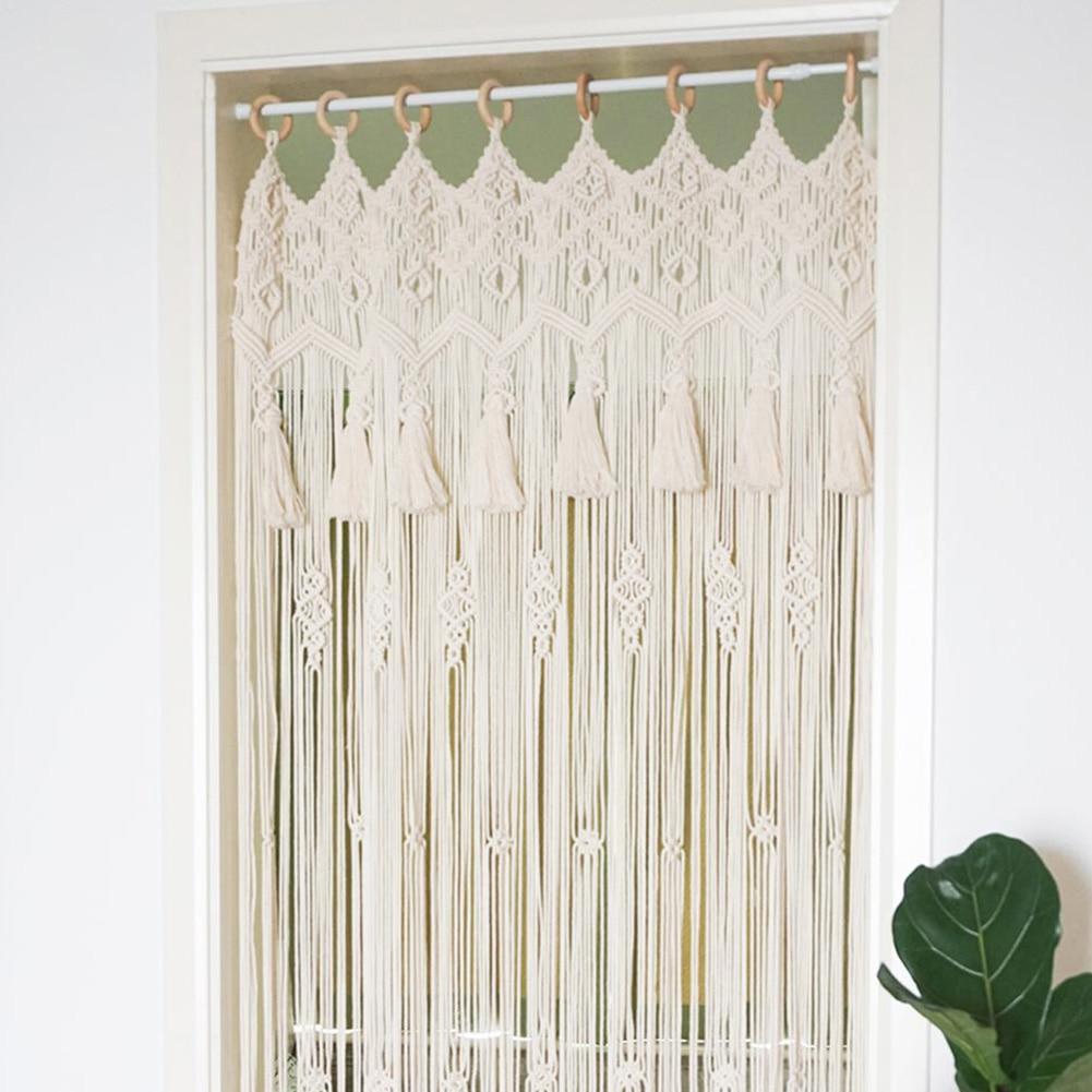 Rideau Macramé Brie Atelier Macramé devant une porte et un mur blanc