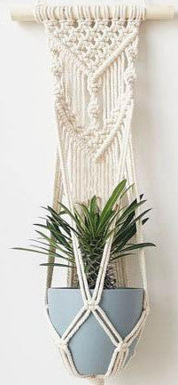 Suspension en Macramé Olivier Atelier Macramé avec un pot de fleur.